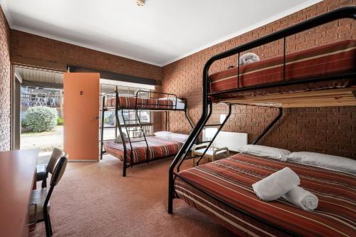 a room with two bunk beds and a table at The Harrietville Snowline Hotel in Harrietville