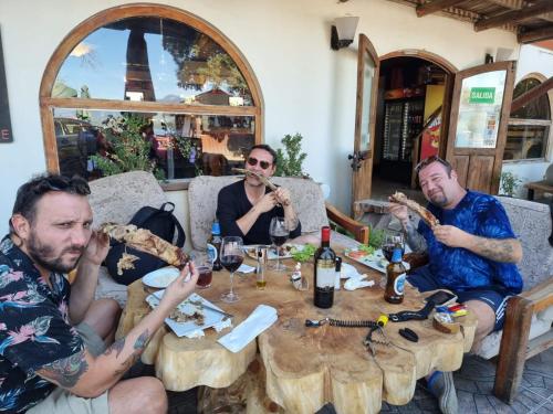 a group of men sitting around a table eating pizza at HARRIS HOTEL Y RESTAURANTE in Licán Ray