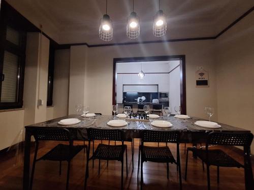 a dining room with a table with chairs and wine glasses at Easy Host Porto in Porto