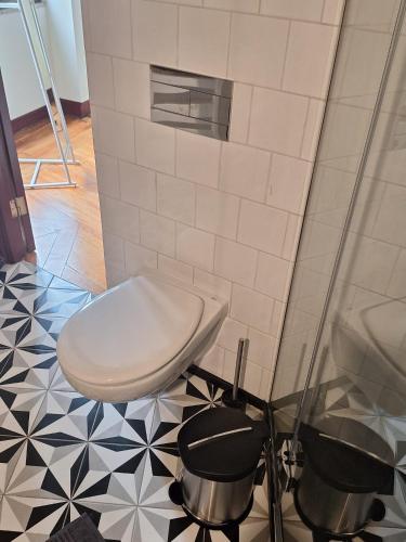a bathroom with a toilet and a tiled floor at Easy Host Porto in Porto