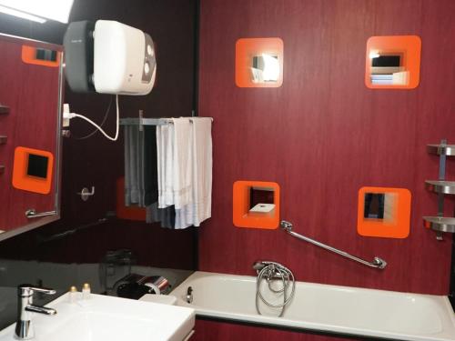 a bathroom with red walls and a sink and a mirror at Charming cottage with pool in Houffalize in Houffalize
