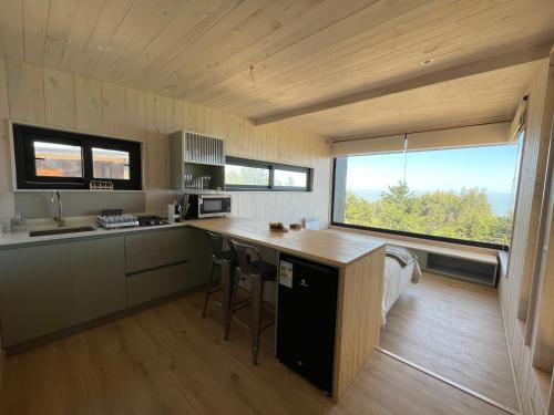a kitchen with a counter and a large window at Chackra Centinela in Navidad