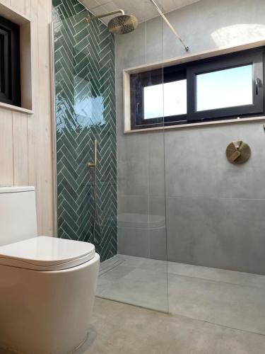 a bathroom with a toilet and a glass shower at Chackra Centinela in Navidad