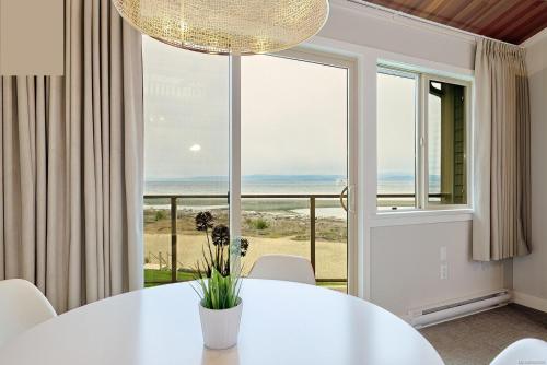 魁利克姆海灘的住宿－Oceanfront Loft - amazing views!，一间带桌子和大窗户的用餐室