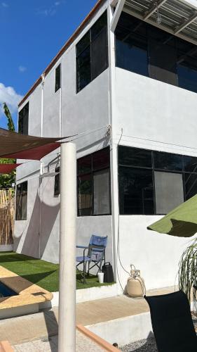a white building with a blue chair in front of it at Departamento Amueblado con Alberca Pedregal B in Tamasopo