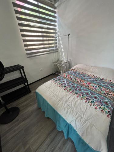 una camera da letto con un letto, una finestra e una sedia di Departamento Amueblado con Alberca Pedregal B a Tamasopo