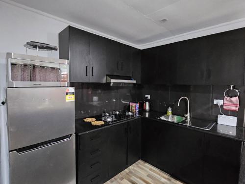 a kitchen with black cabinets and a stainless steel refrigerator at Blissful Calm in Nadi