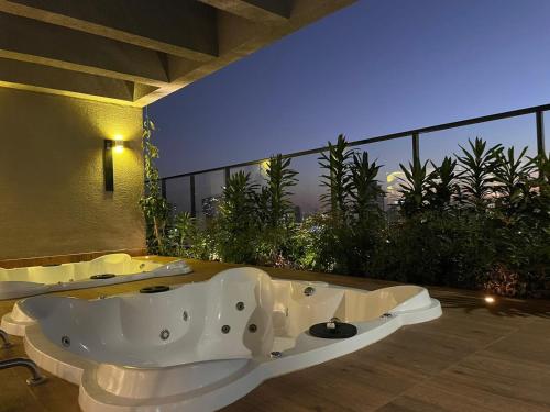 a bathroom with a bath tub on a balcony at Vida Urbana - Connect - Setor Oeste in Goiânia