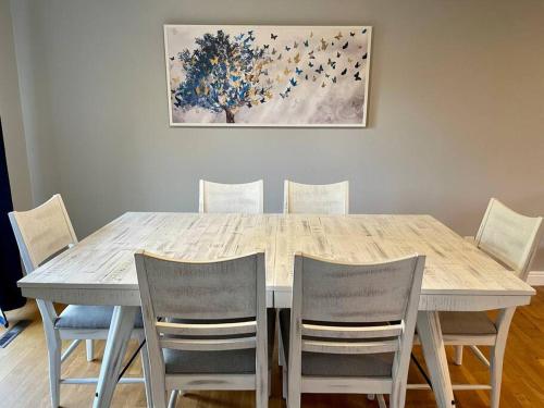 una mesa de comedor con 4 sillas y una pintura en Spacious 4 bdr w/ Game Room 5 min Drive to College, en Boulder