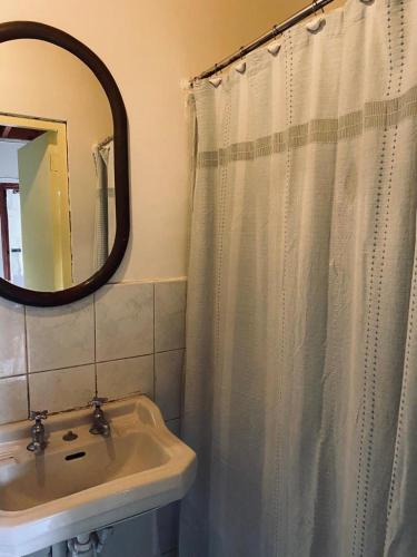 baño con lavabo y cortina de ducha en Habitación tranquila e independiente al lado de la naturaleza y a las faldas del cerro San Cristóbal,, en Santiago