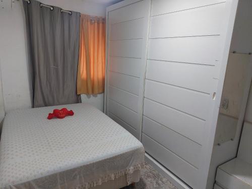 Un dormitorio con una cama con una cinta roja. en Apartamento Rio Centro, en Río de Janeiro