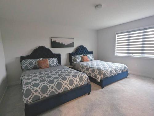 a bedroom with two beds and a window at Stylish 5-Bedroom Retreat Near Port Dover and Turkey Point Beach in Simcoe