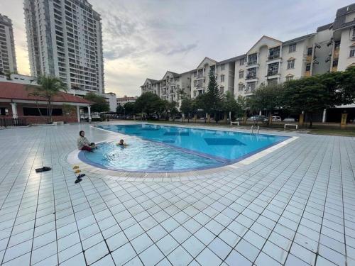 un homme assis dans une piscine d'une ville dans l'établissement Bahtek Home with pool & private parking, à Ampang