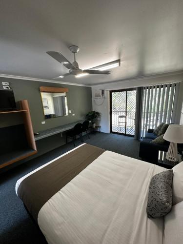 a bedroom with a large bed and a living room at Murgon Motor Inn in Murgon