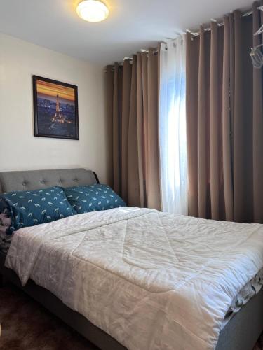 1 dormitorio con 1 cama y una ventana con cortinas en HM Cozy Place beside Enchanted Kingdom, en Santa Rosa