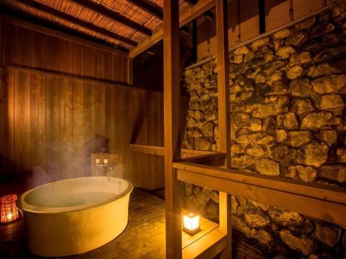 下呂的住宿－Yukai Resort Gero Saichoraku Bekkan，石墙客房内的浴缸