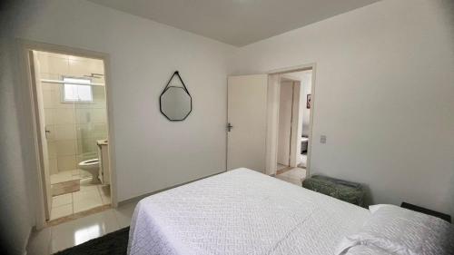 a bedroom with a bed and a bathroom with a mirror at Apto próximo ao roteiro do vinho in São Roque