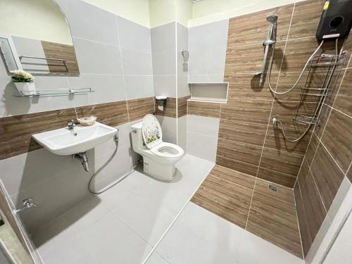 La salle de bains est pourvue de toilettes, d'un lavabo et d'une douche. dans l'établissement BAAN OZONE, à Hat Yai
