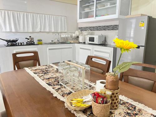 une cuisine avec une table en bois et une table sidx sidx sidx dans l'établissement BAAN OZONE, à Hat Yai
