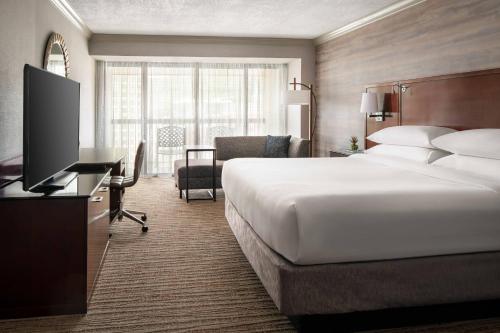 a hotel room with a bed and a desk with a television at Salt Lake Marriott Downtown at City Creek in Salt Lake City