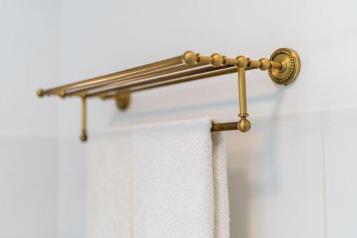 a gold shower curtain rod with a white towel at Apartament przy Czarnej Bramie in Kłodzko