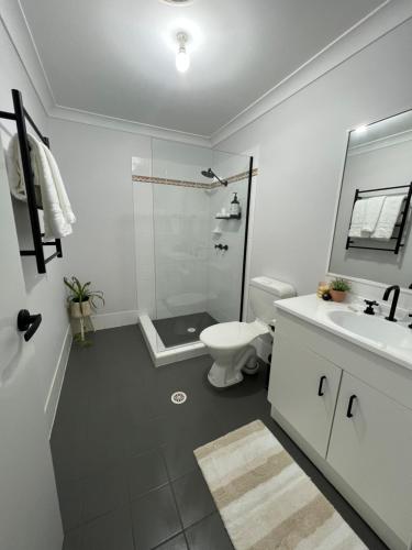 a bathroom with a shower and a toilet and a sink at Sussex Gem - Cozy apartment in the heart of Sussex in Sussex Inlet