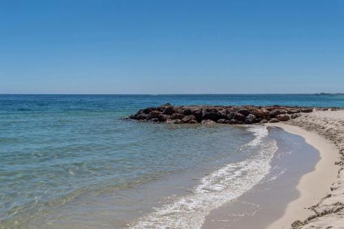 a sandy beach with rocks in the water at Escape to 67 at Cape View in Broadwater