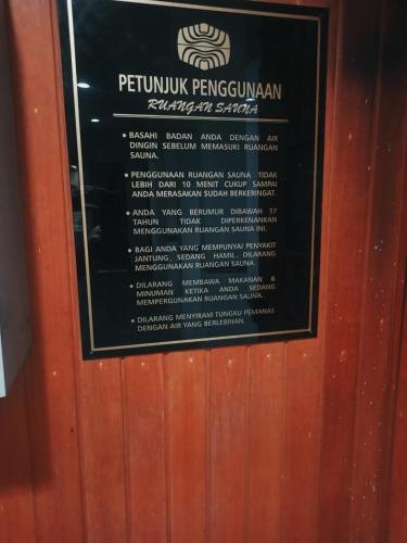 a sign on a wooden door with a sign on it at Horison Ultima Bandung in Bandung