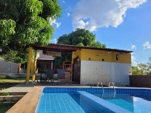 a villa with a swimming pool in front of a house at Rancho Santa Helena in Juazeiro