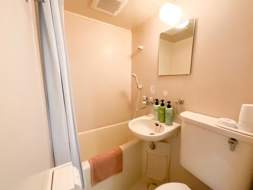 een badkamer met een douche, een toilet en een wastafel bij ローヤルハイツ菊水駅 in Sapporo