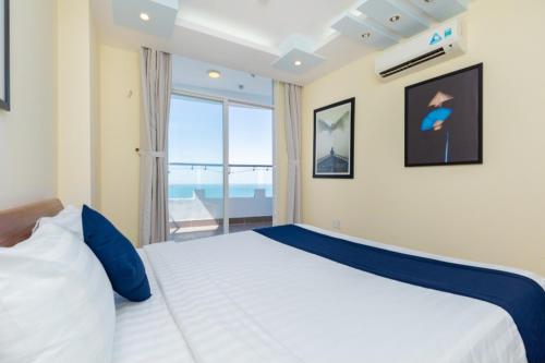 a bedroom with a bed and a large window at Amazing Seaview - Thuy Tien Building in Vung Tau