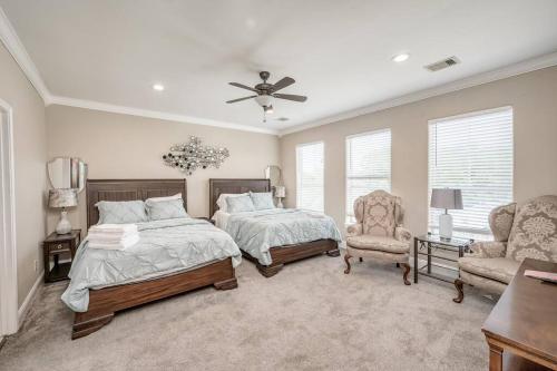 a bedroom with two beds and a chair and a ceiling fan at Gorgeous Home w/ Amazing View of Houston Skyline in Houston