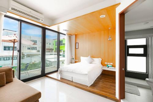 a bedroom with a white bed and a large window at 野居海景渡假民宿Simple Life Home Stay in Magong