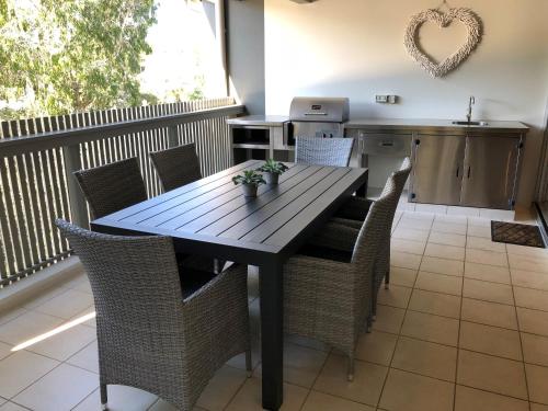 una mesa de madera y sillas en la cocina en East On Byron Bay Apartments, en Byron Bay