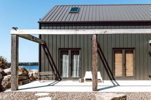 a green building with a roof and a house at The Barn - Georges Bay, St Helens in St Helens