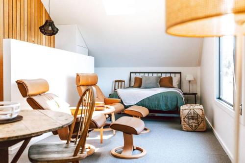 a bedroom with a bed and a table and chairs at The Barn - Georges Bay, St Helens in St Helens