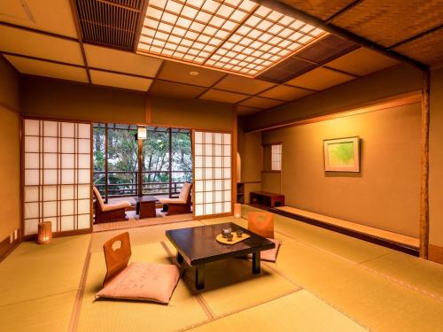 een kamer met een tafel en stoelen in een kamer bij Yukai Resort Premium Yoshinoya Irokuen in Kaga