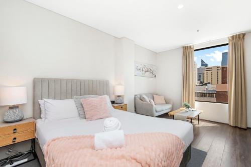 パースにある802 Serenity Studio Apt For 2high Floorのベッドと椅子と窓のある寝室