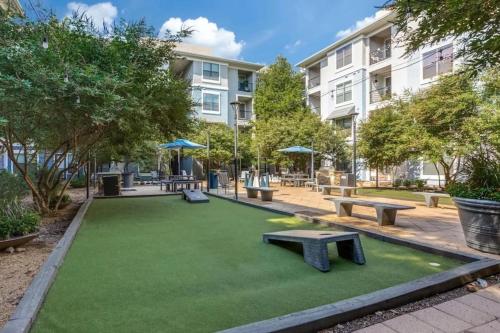 a artificial lawn with benches and tables in a park at Peaceful apartment in Frisco