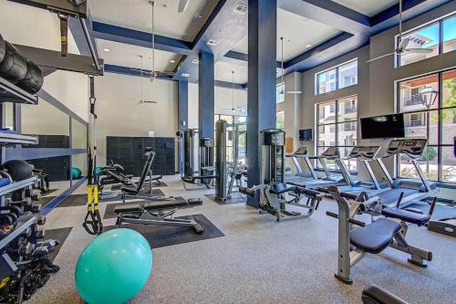 a gym with a lot of treadmills and machines at Peaceful apartment in Frisco