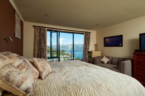 - une chambre avec un lit et une grande fenêtre dans l'établissement Akaroa holiday home Spacious and quite with stunning harbour views and close to town, à Akaroa