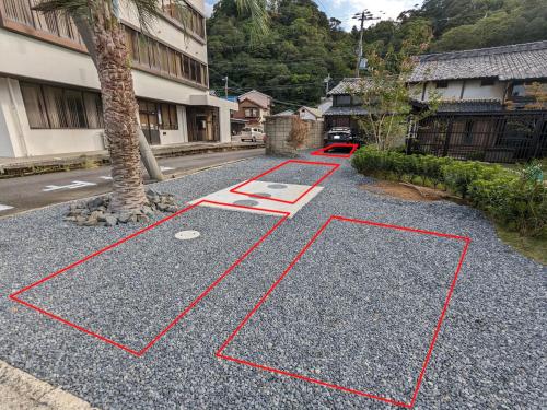 a road with red lines on the ground next to a tree at KOZA River House 湯川邸 in Koza