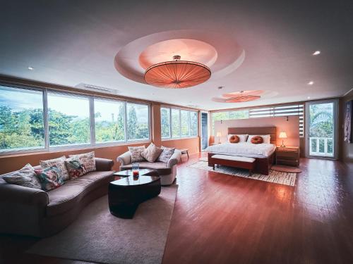 Wazobia Boracay في بوراكاي: غرفة معيشة كبيرة مع سرير وأريكة