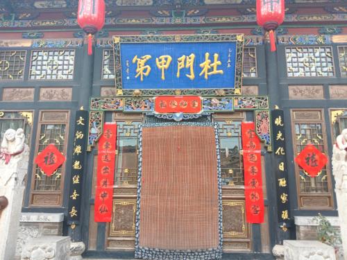 an entrance to a temple with red and blue signs at Pingyao hu lu wa Home Inn in Pingyao