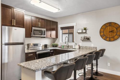 a kitchen with a counter with chairs and a refrigerator at The Yellowstone Hideaway Unit B in West Yellowstone