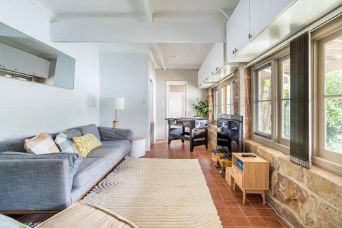 a living room with a couch and a table at rivescape holiday home at Berowra Waters in Berrilee