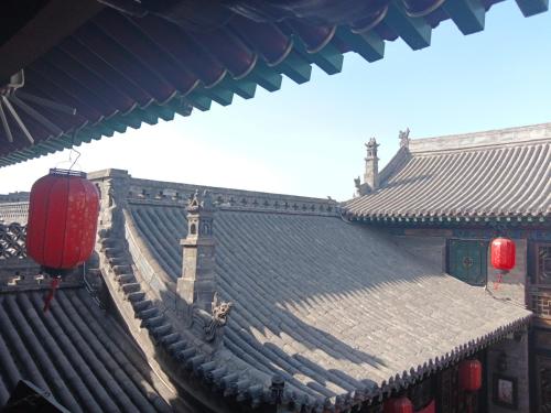 ein Dach eines asiatischen Gebäudes mit roten Laternen in der Unterkunft Pingyao hu lu wa Home Inn in Pingyao