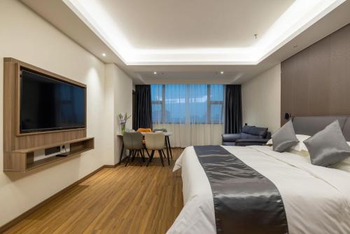 a hotel room with a large bed and a flat screen tv at Citadines Zhengda Mall Hefei in Hefei
