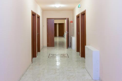 a hallway with wooden doors and a tile floor at Zajazd Beskidy in Żywiec