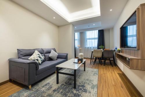 a living room with a couch and a table at Citadines Zhengda Mall Hefei in Hefei
